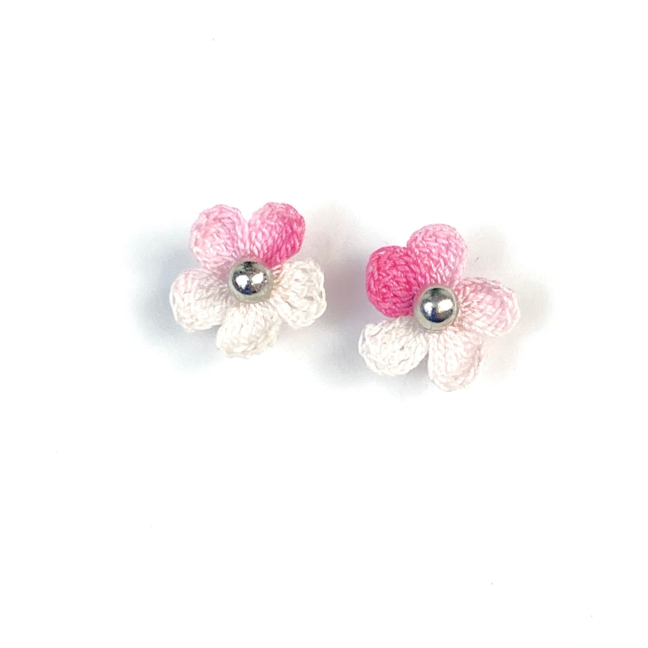 Pair of pink crochet flower earrings on a white background