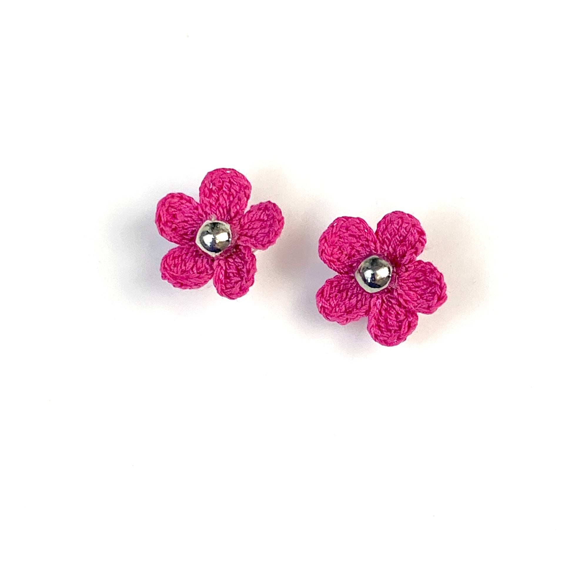 Pair of magenta crochet flower earrings on a white background