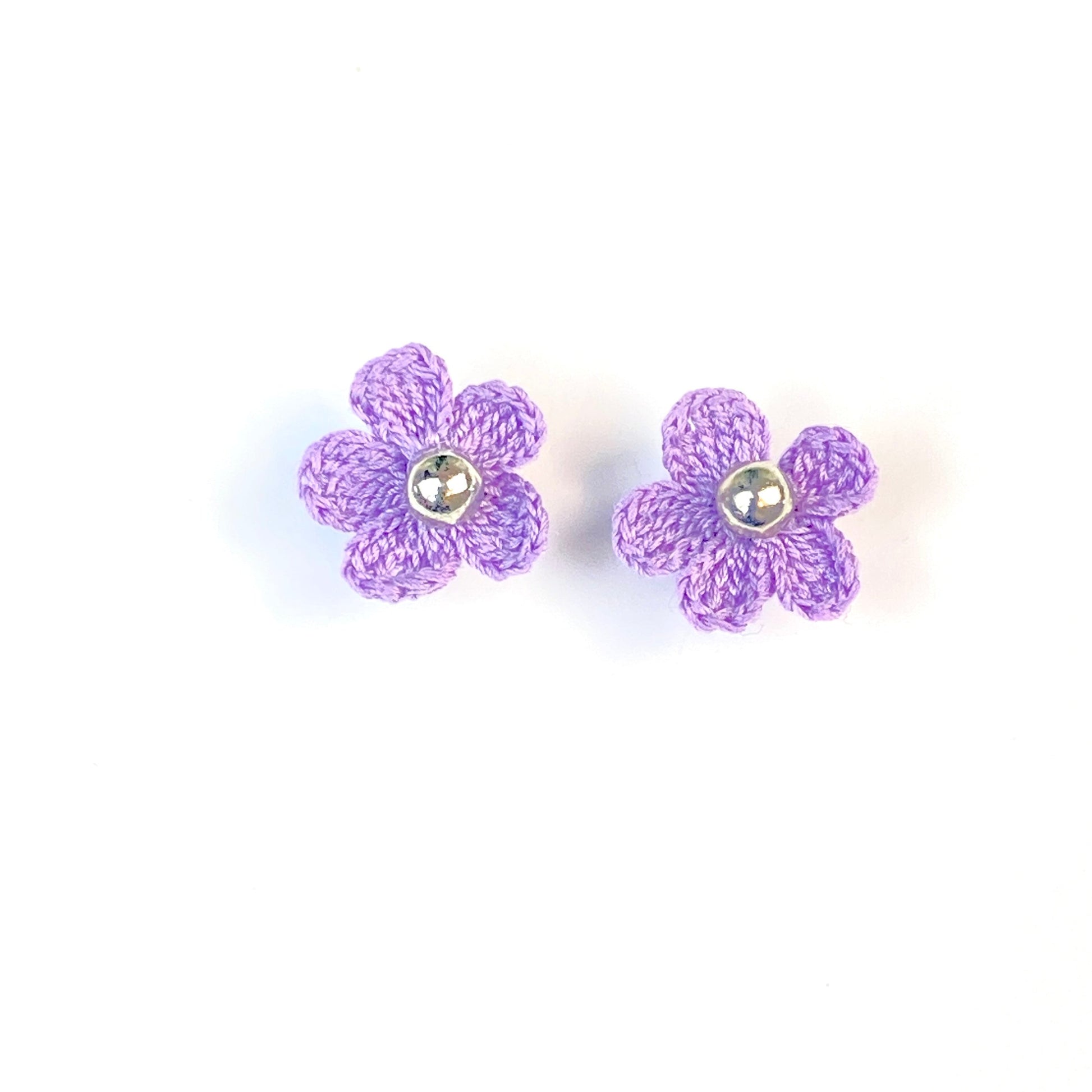 Pair of purple crochet flower earrings on a white background