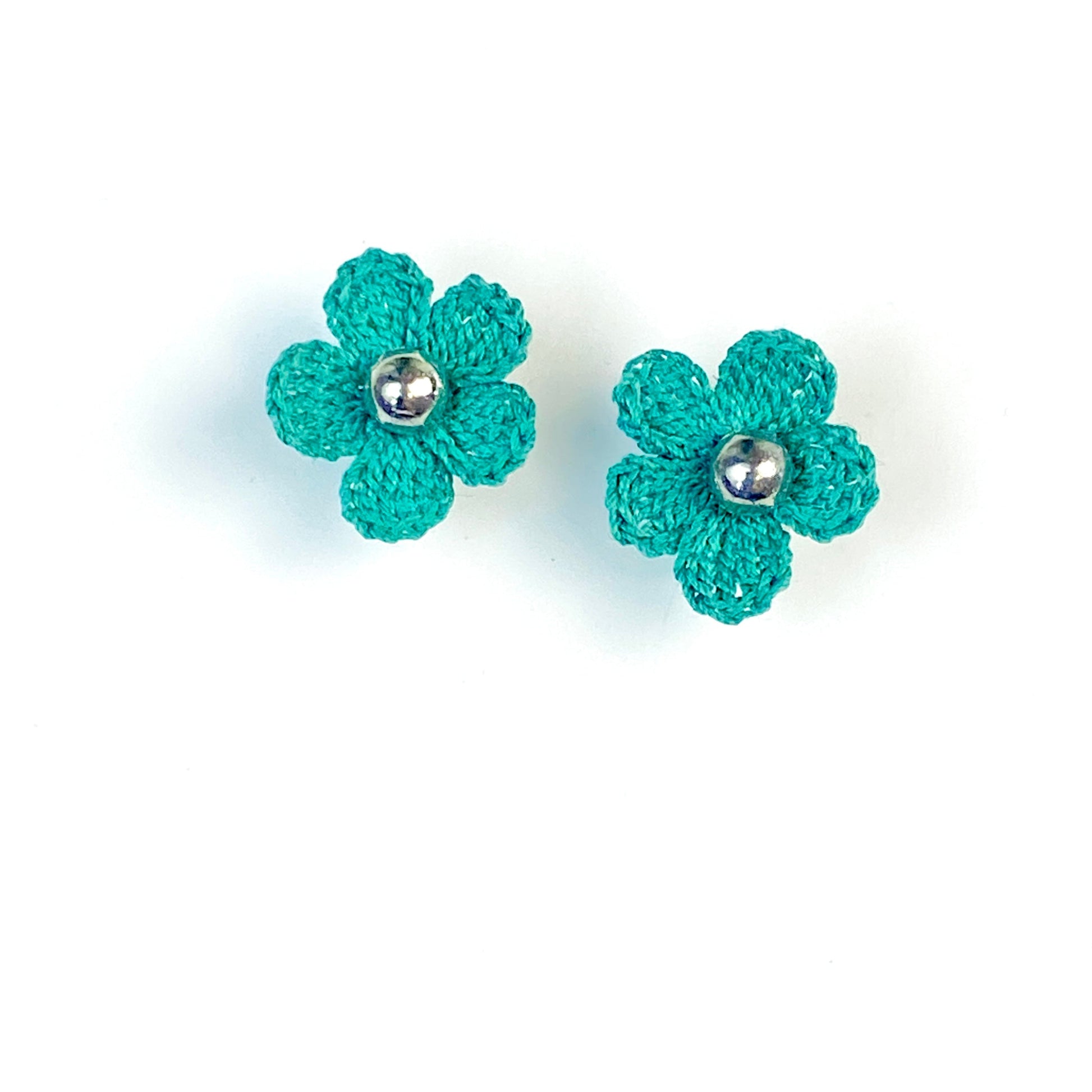 Pair of teal crochet flower earrings on a white background
