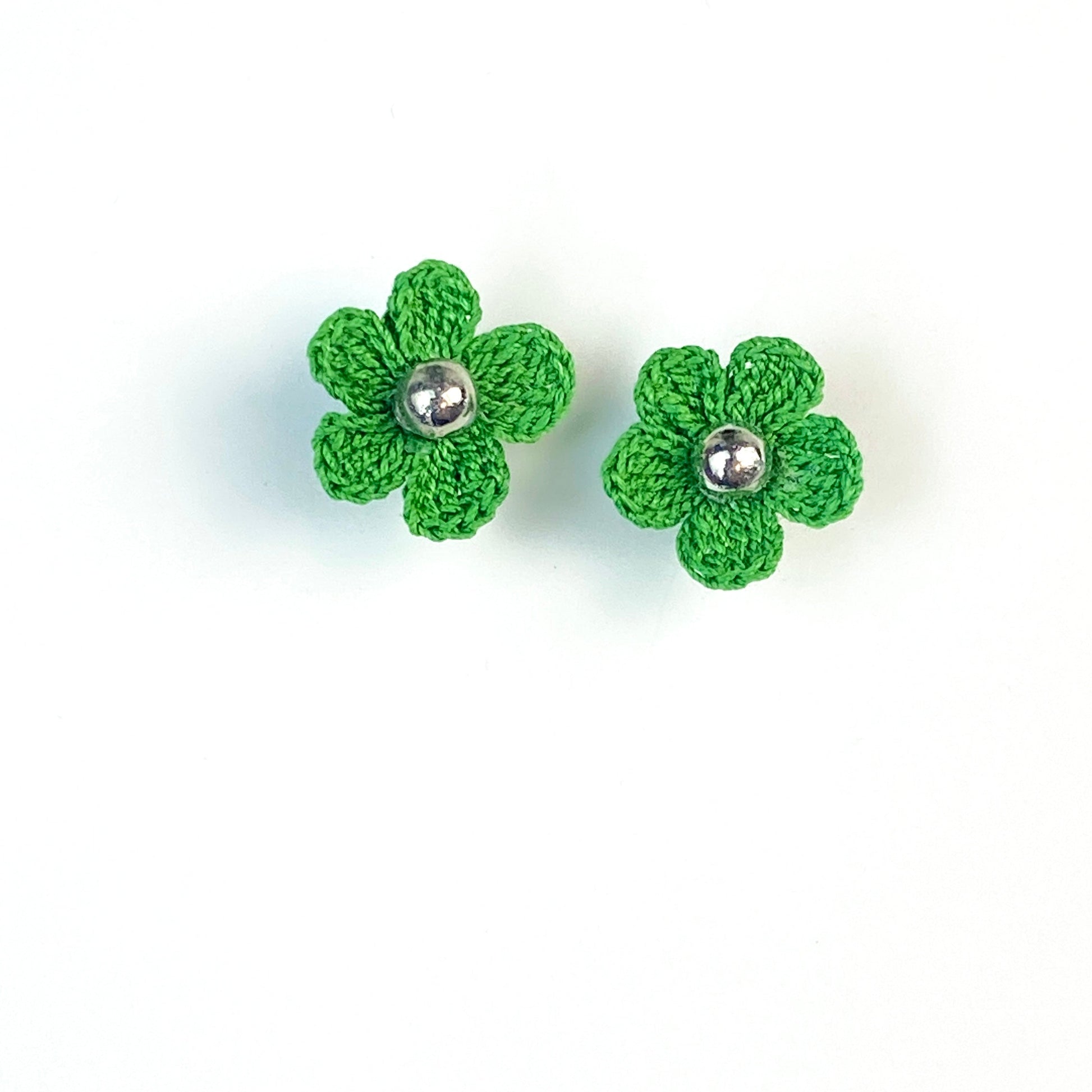 Pair of green crochet flower earrings on a white background