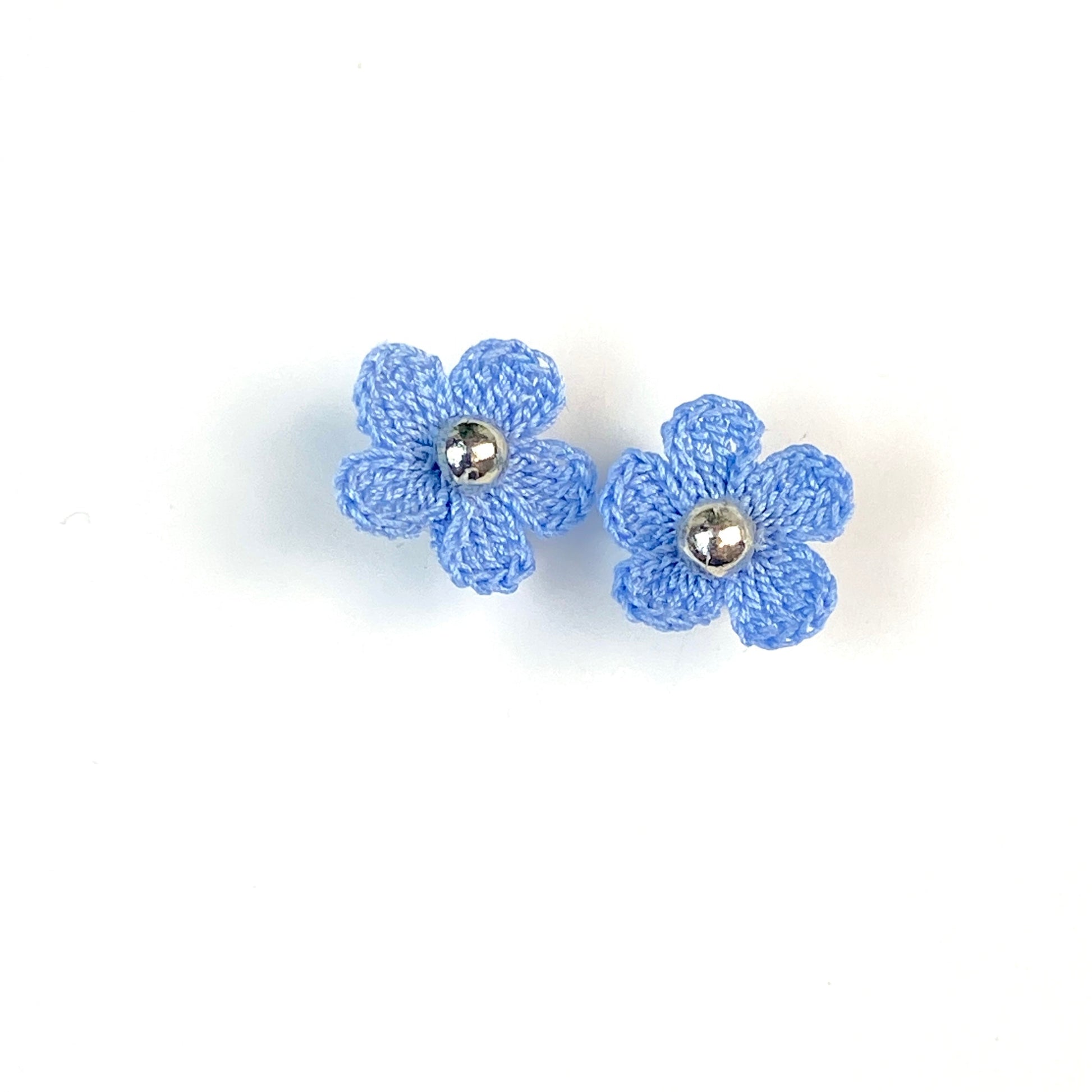 Pair of light blue crochet flower earrings on a white background