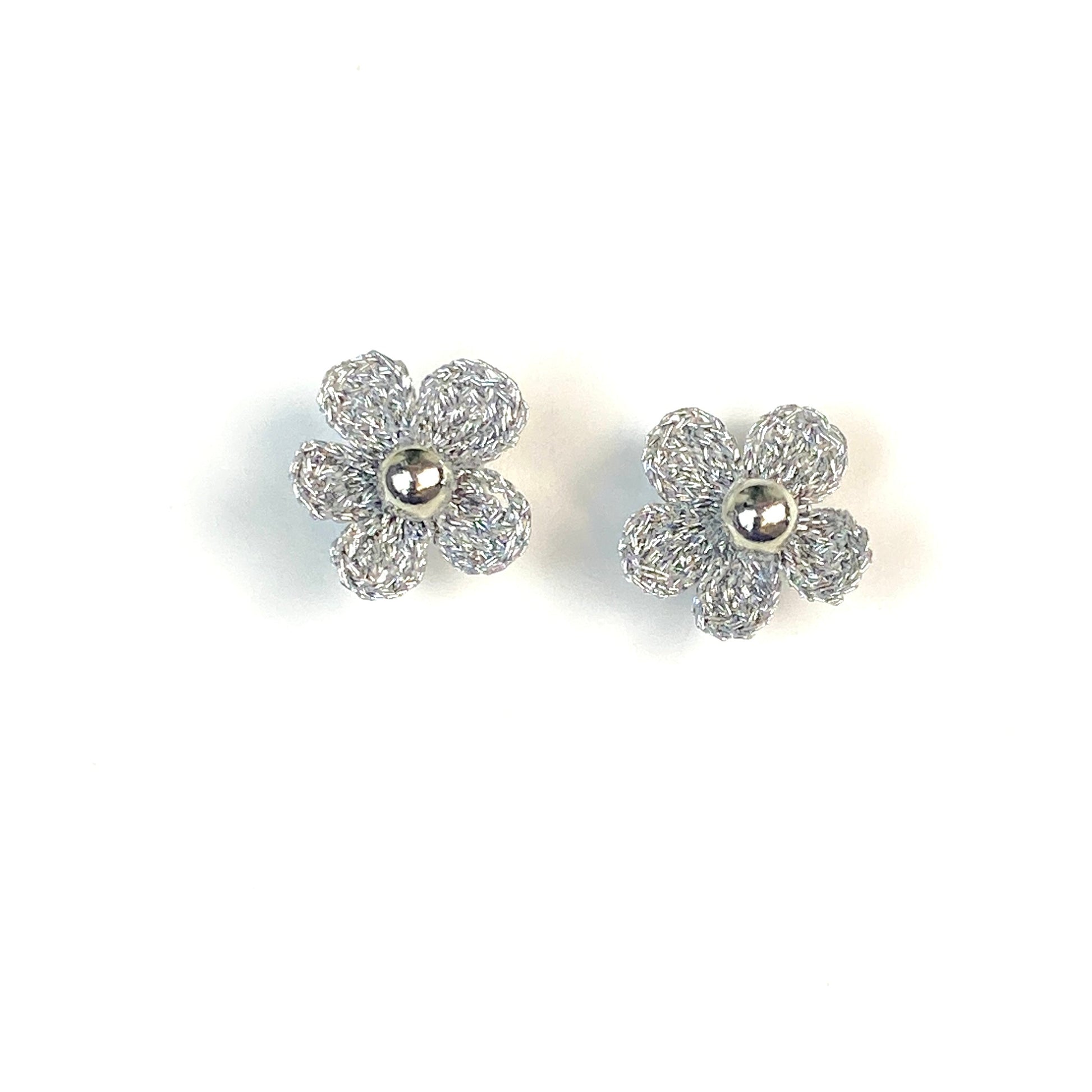 Pair of silver crochet flower earrings on a white background