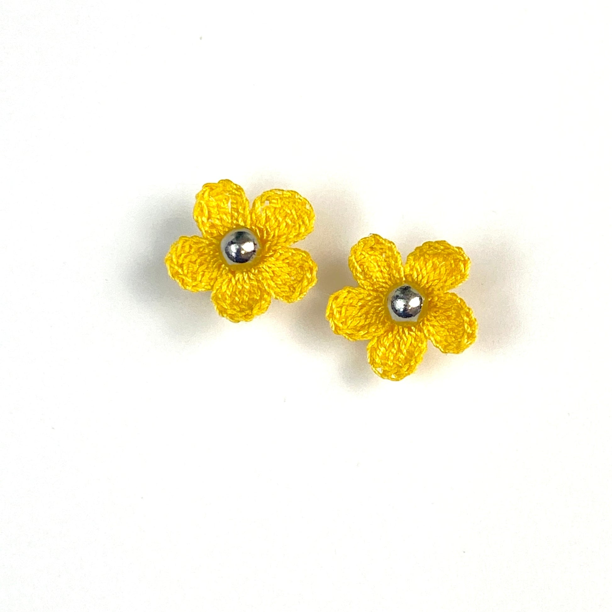 Pair of yellow crochet flower earrings on a white background