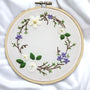 Embroidery hoop with floral design on a white fabric background