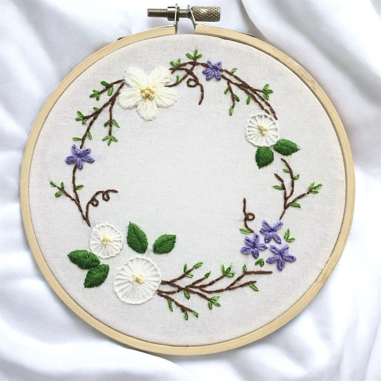 Embroidery hoop with floral design on a white fabric background
