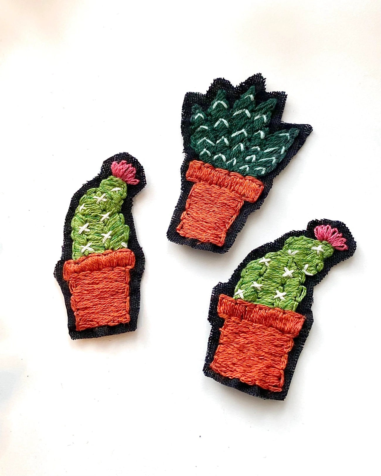 Three embroidered cactus patches in different pot styles, arranged on a plain white background.